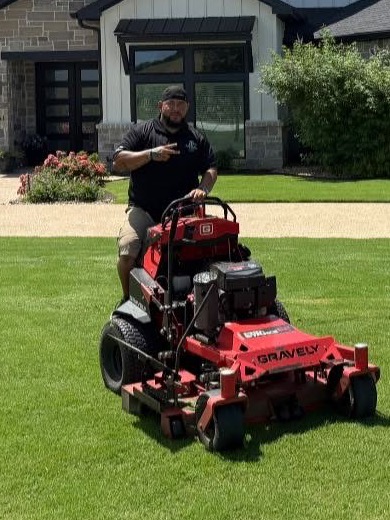 Jonathan Garcia on a red mower at a freshly maintained property